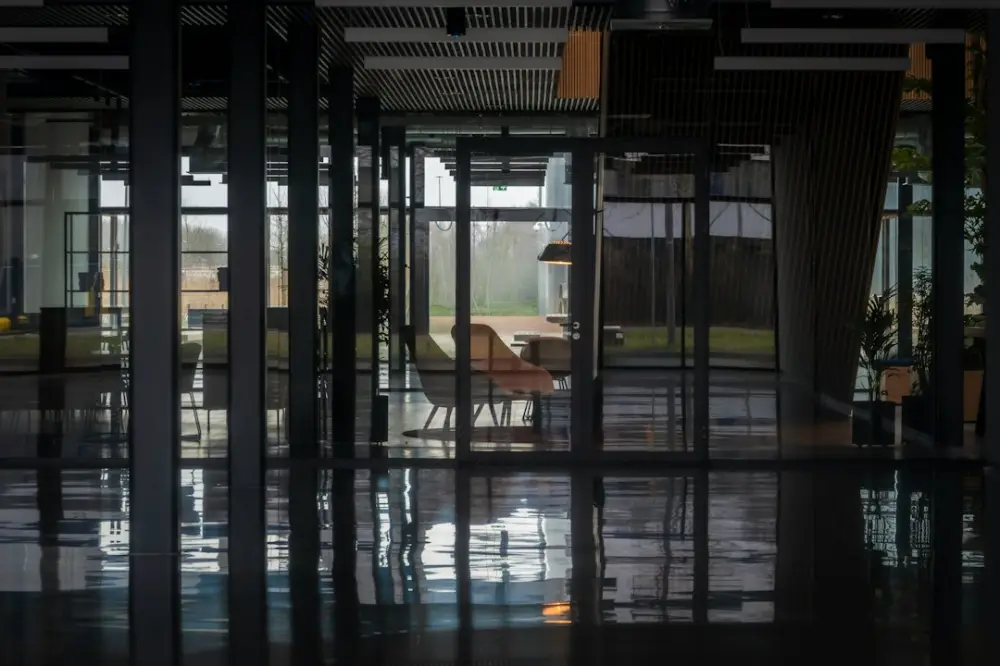 Modern office interior with glass walls and reflections, illustrating leadership and systems